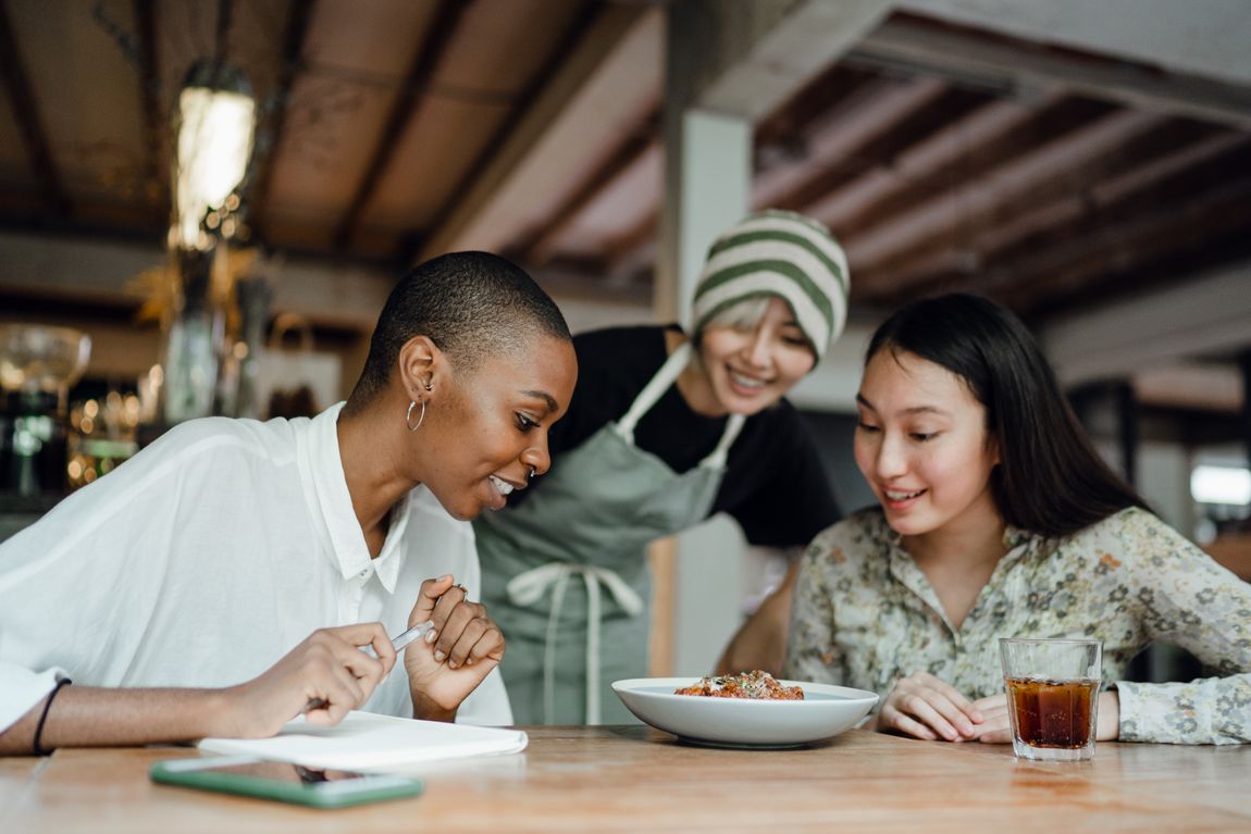 Friends smiling together over food at a restaurant